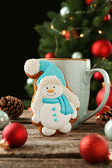 Poster - Delicious cookie in shape of snowman, cup with cocoa and Christmas decor on wooden table