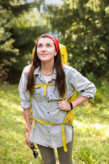 Wall Mural - Young hiker with backpack looking at something in forest