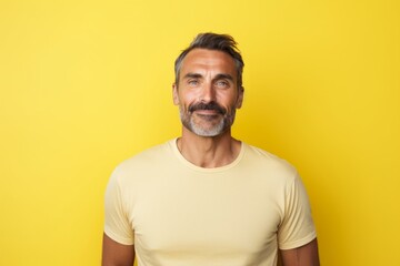 Wall Mural - Portrait of a blissful man in his 40s sporting a breathable mesh jersey isolated in pastel yellow background