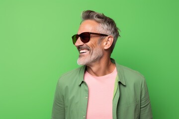 Portrait of a blissful man in his 40s wearing a trendy sunglasses isolated on pastel green background