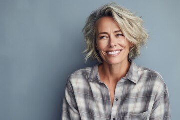 Canvas Print - Portrait of a blissful woman in her 40s wearing a comfy flannel shirt in front of pastel gray background