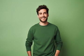 Wall Mural - Portrait of a satisfied man in his 20s showing off a thermal merino wool top in soft green background