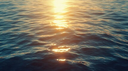 A calm ocean surface with soft waves reflecting the light of the setting sun.