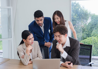 Business team woman and man asian group meeting sitting on desk looking talk think creative idea computer on table ready happy working new project job online product sale marketing in office company.