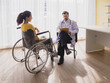 © Singh - Health care latin woman sick sit wheelchair with man doctor caucasian two people check and treat patients talk help support explain medicine sick person in take care your health hospital clinic room.