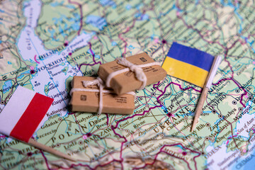 The flag of Poland and Ukraine lie on the world map next to delivered parcels. Economy, aid, trade