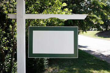 Blank White And Green Signpost In Front Of Foliage.