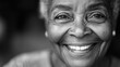 © Taras Vykhopen - A joyful elderly African American woman with expressive eyes and gentle wrinkles in a minimalistic black and white close-up