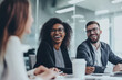 © Sitthikorn - Group of colleagues engaging in a discussion during a business meeting in a conference room. Happy business people, men and women