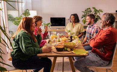 Happy multiethnic family and friends having dinner together at home