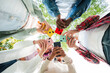 © Jose Calsina - Low angle view of group of friends standing in circle, all using cellphones outdoors. Vibrant smartphone colors contrast the sky, showing modern technology and social connection in urban setting.