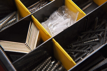 Stacked various shurps and nails in the organizer, side view, close-up