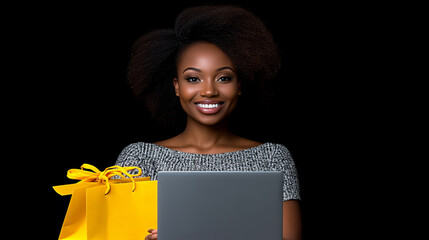 Joyful Online Shopping: A vibrant young woman with a radiant smile holds a laptop and yellow shopping bag against a stark black background, capturing the excitement of online retail therapy.