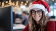© Pinklife - A smiling woman wearing a Santa hat exudes warmth and joy while sitting at her desk in a lively office space adorned with festive decorations and sparkling lights.