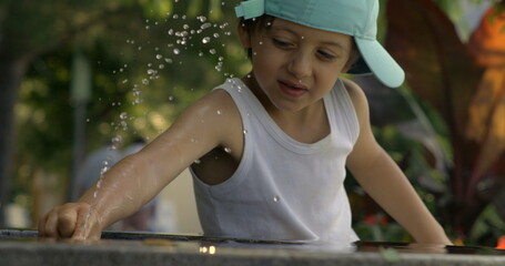 Child playing with water in slow motion at 800 fps, emphasizing the joy and playful interaction with splashing water droplets