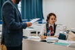 © qunica.com - A professor is helping a student with her assignments during a classroom session. The student is focused on her work, while the professor provides guidance and support.