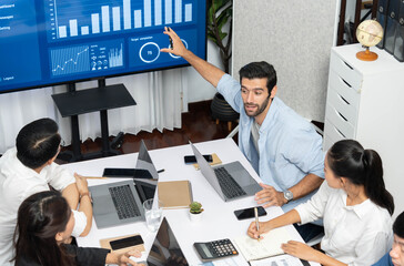 Analyst team utilizing BI Fintech to analyze financial data at table in meeting room. Businesspeople analyzing BI dashboard power for business insight and strategic marketing planning. Prudent