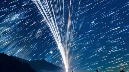 Aufkleber - Long exposure showing the motion of stars in the night sky, creating a mesmerizing display of star trails above a dark mountain range