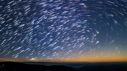 Poster - Capturing the beauty of the night sky with star trails forming circles as dawn gently illuminates the horizon