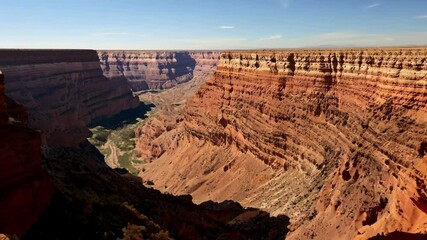 Poster - Sunlight illuminating the vast landscape of canyon de chelly national monument, showcasing the majestic rock formations and the canyon floor below