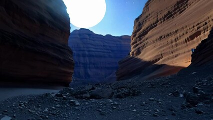 Aufkleber - Narrow canyon with steep walls and rocky ground is illuminated by the last light of the setting sun, creating a dramatic and awe inspiring scene
