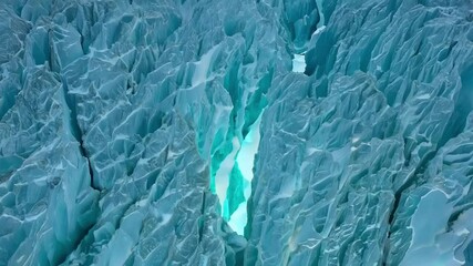 Aufkleber - Sun shining through deep glacier crevasse creates mesmerizing turquoise glow in ice. Illuminating frozen landscape with intricate patterns and textures