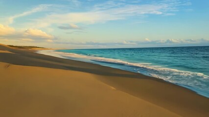 Poster - The turquoise ocean waves gently crash on the golden sandy beach under a bright blue sky with fluffy white clouds, creating a tranquil tropical paradise perfect for a relaxing summer vacation
