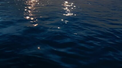 Aufkleber - Sunset light reflects on dark blue water, creating a mesmerizing abstract background with rippling waves for a peaceful evening by the sea. Enjoy serene twilight nature