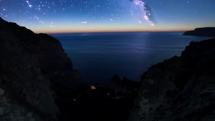 Aufkleber - Dark ocean water crashing between two large cliffs, lit by the setting sun with a faint light illuminating the water in the distance