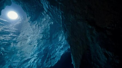 Aufkleber - Light filtering through a hole in a dark ice cave, casting a soft glow on the textured icy wall, creating mesmerizing shadows and patterns