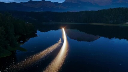 Aufkleber - Beam of bright light streaks across the night sky, its reflection shimmering on the surface of a serene lake surrounded by a dark forest