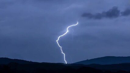 Aufkleber - Bright bolt of lightning striking in the distance, illuminating the night sky and the silhouette of a mountain range below