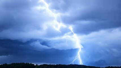 Wall Mural - dark storm clouds fill the sky over a forest silhouette, hinting at heavy rain. the atmosphere is ch