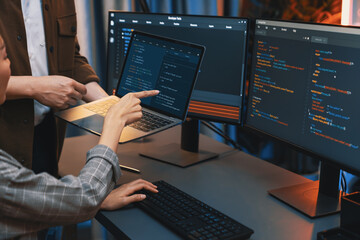 Serious of IT developers discussing intelligent website development coder system running data online two screens with laptop showing information network at neon light room at modern office. Infobahn.