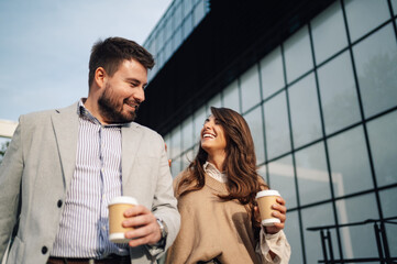 Wall Mural - Business people walking outside office building holding coffee and smiling