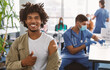 © Prostock-studio - Successful Covid-19 Vaccination Concept. Vaccinated Black Man Gesturing Thumb Up And Showing Arm With Adhesive Bandage After Vaccine Injection, Posing Sitting At Clinic Hospital, Blurred Background