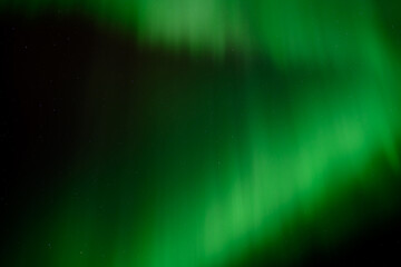 Wall Mural - a dark night sky filled with bright green aurora creating patterns, sky only