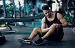 © Prostock-studio - Sport Trauma. Young Arab Male Athlete Touching His Hurted Knee At Gym, Upset Middle Eastern Guy Sitting On Floor And Massaging Sore Injured Leg After Workout Training In Fitness Club, Free Space