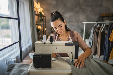 Adult woman tailor sewing clothes on electric sewing machine