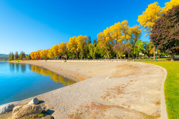 Autumn view of the city park and city beach alongside waterfront homes on Lake Coeur d'Alene, in the downtown resort district of Coeur d'Alene, Idaho.