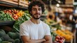 © Zaenal - A young man stands confidently in a vibrant produce market, surrounded by fresh vegetables and fruits.