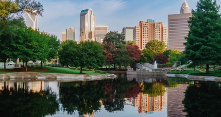 Pond in Marshall Park and downtown city skyline of skyscrapers at sunrise. Charlotte, North Carolina, United States.