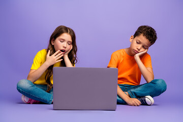 Poster - Full size photo of charming two little children tired netbook online lesson wear trendy orange yellow outfit isolated on violet background