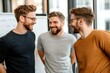 © LifeMedia - Three casually dressed men engage in joyful conversation inside a contemporary office, exuding a relaxed and collaborative atmosphere amidst modern decor.
