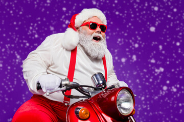 Wall Mural - Photo of santa claus role man riding newyear x-mas theme party by bike excited to see friends wear sun spectacles trousers hat suspenders isolated purple background