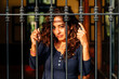 © Peruphotoart - Warm portrait of a cheerful woman standing behind a gate at golden hour