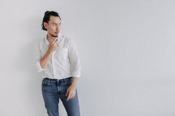 Doubt face Long hair Asian man bun in white shirt and jean stand on white.