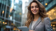 © Aino Minako - A woman is smiling and holding a tablet in her hand