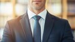 © Whitefeather - A man in a suit and tie stands in front of a bookshelf. Concept of professionalism and authority, as the man is dressed in a business suit and tie