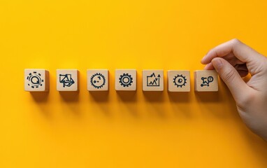 A creative visual showing a hand assembling wooden blocks into a sequence that demonstrates workflow automation and management processes, placed on a clean yellow background 